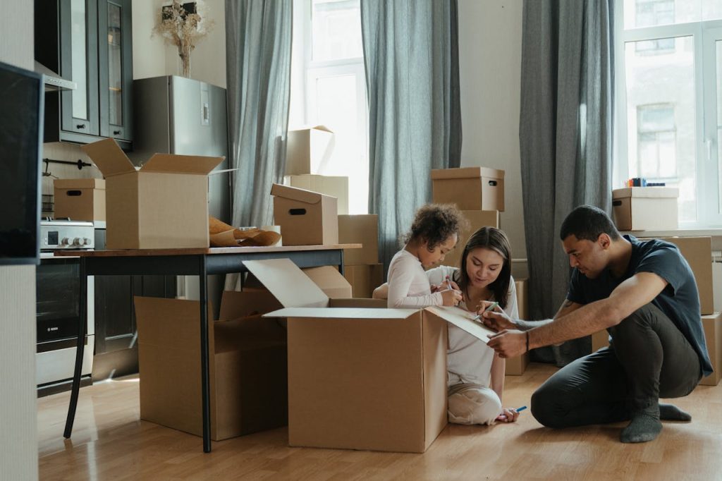 family-unpacking-after-moving-4569340 A family unpacks moving boxes in their new home kitchen, creating a cozy atmosphere.